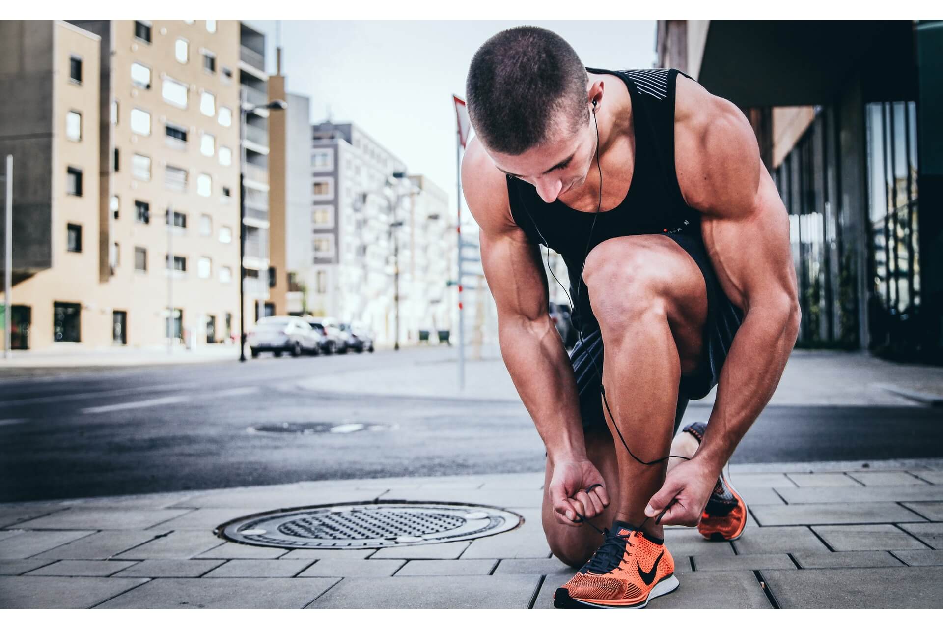 A man on his knees tying his shoes