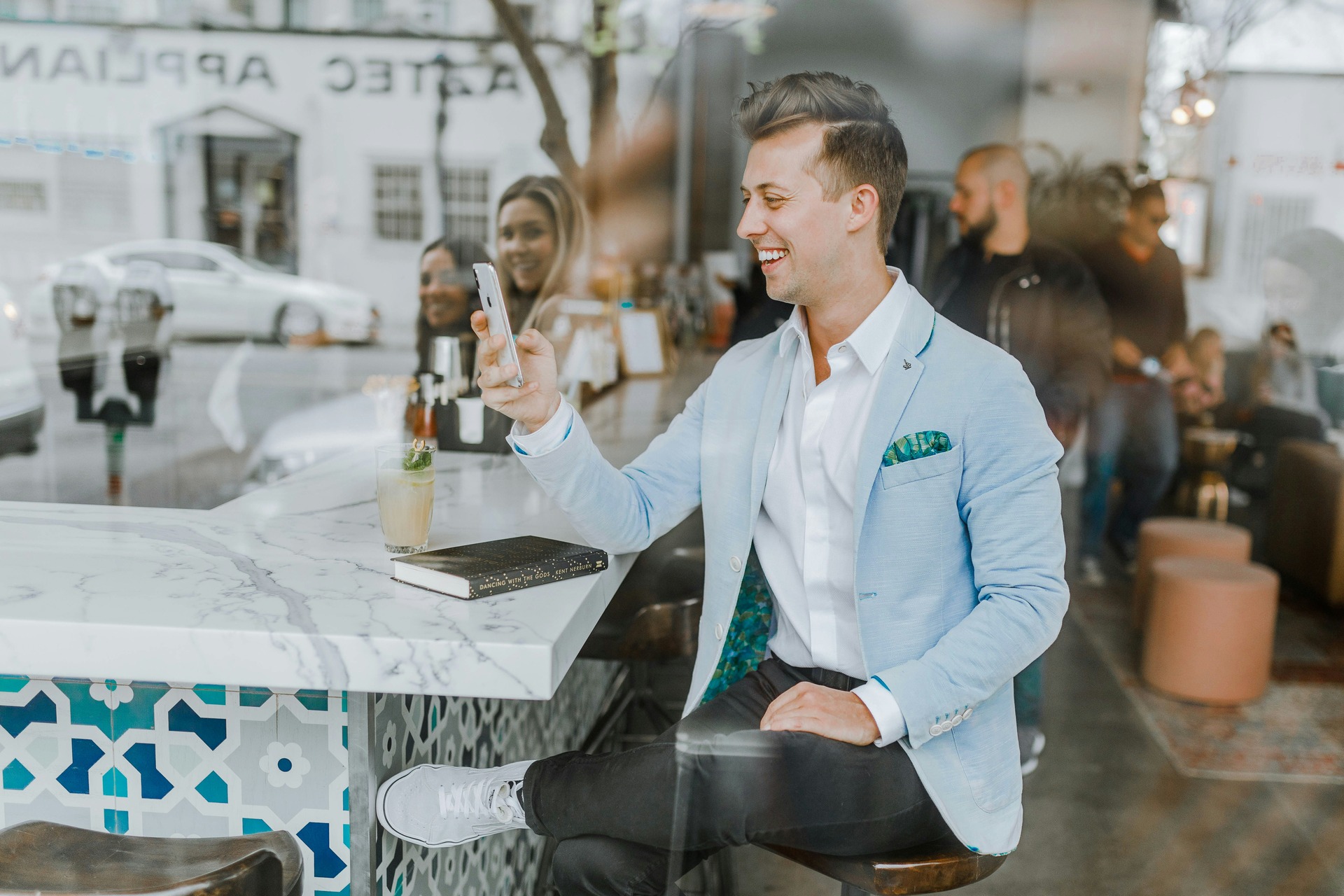 Man at a restaurant using his phone and getting checked by women