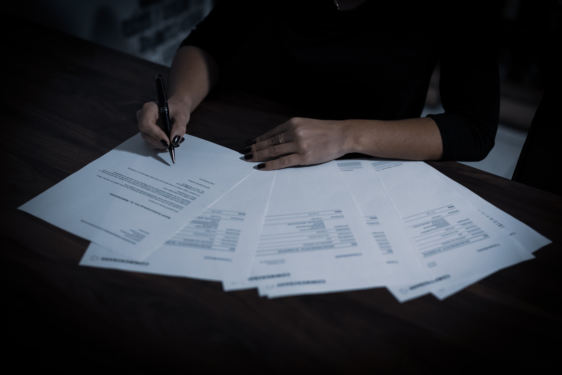 Woman signing a stack of forms