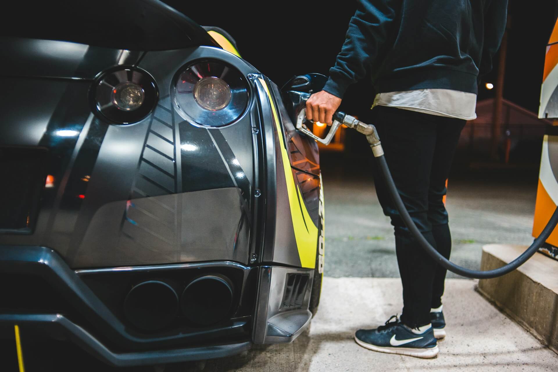 Man pumping gas into sports car