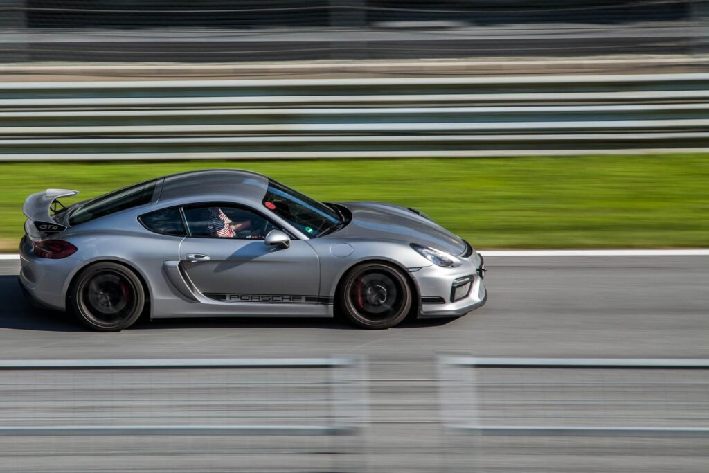 A gray Porsche drives around a track