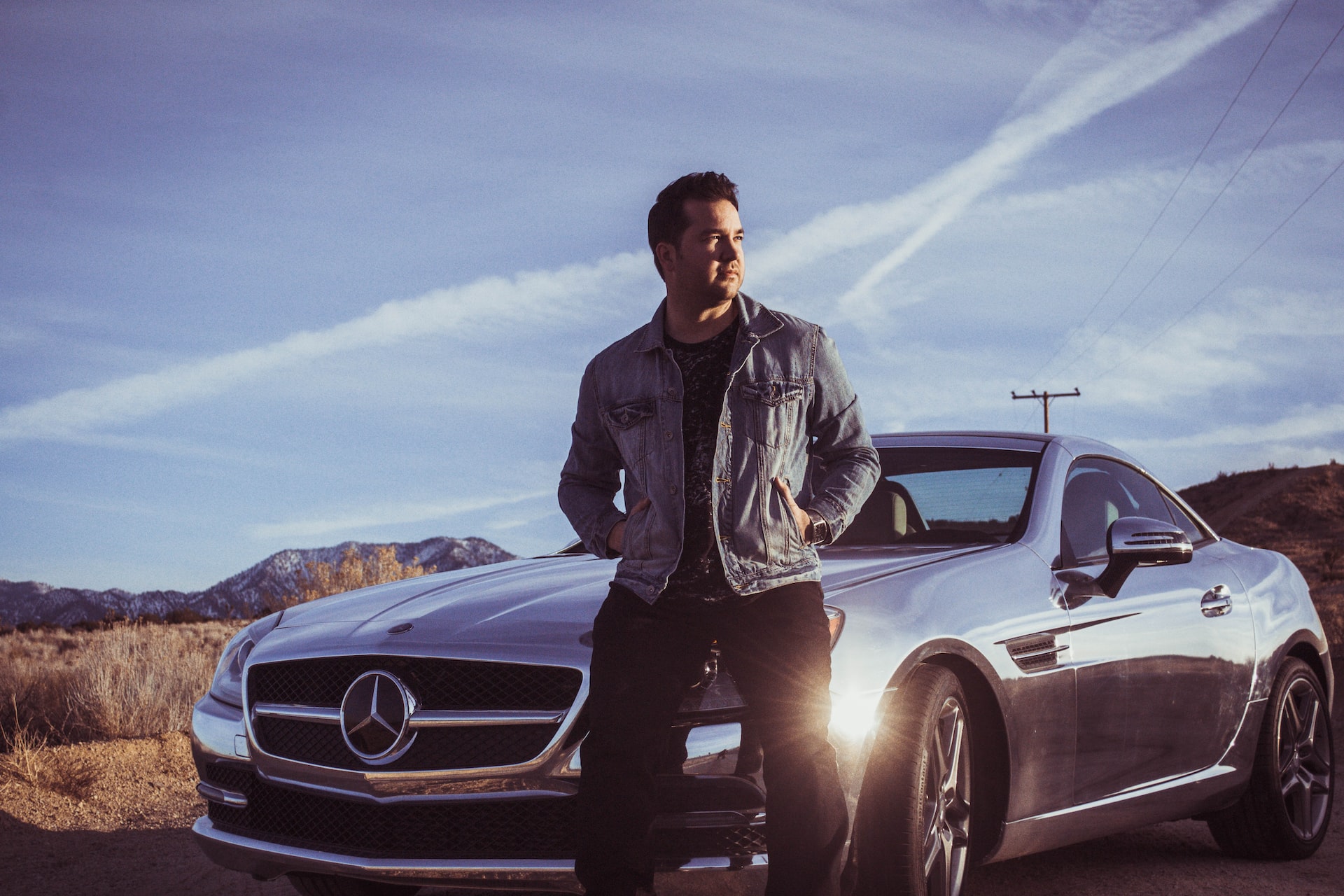 Man in jacket standing next to car.