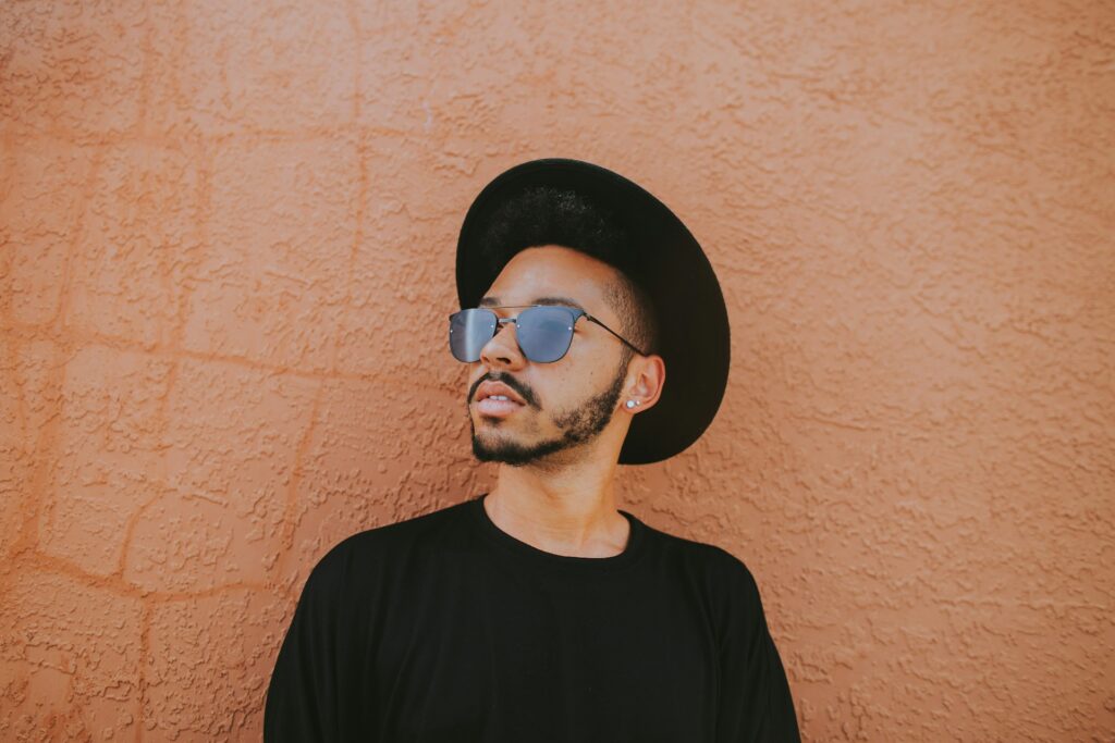 A young man in a wide-brimmed hat and sunglasses