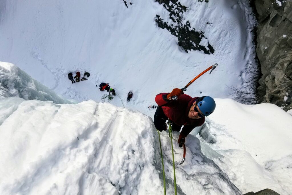 Man ice climbing with pick