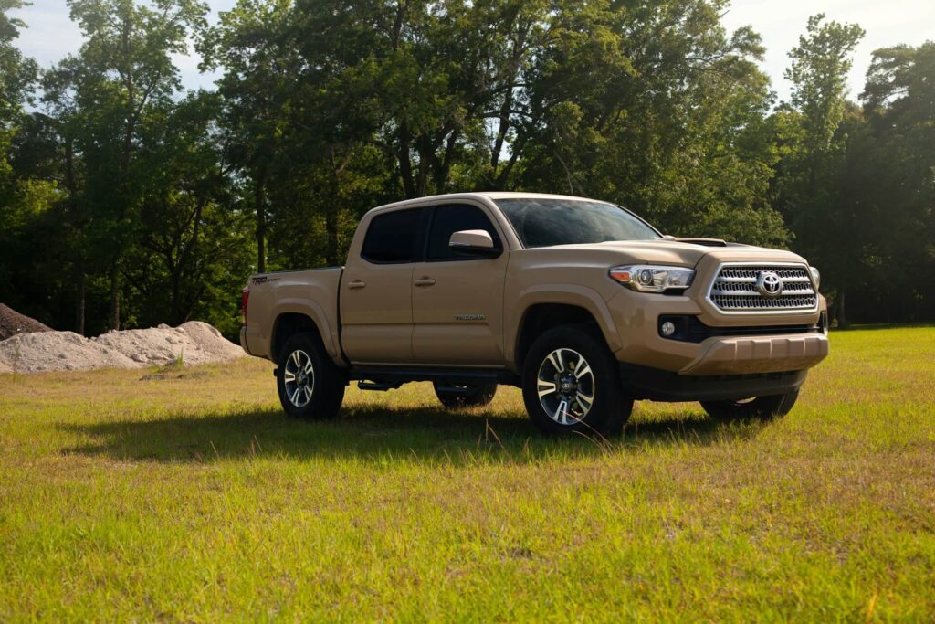 Brown Toyota Tacoma in a field of grass