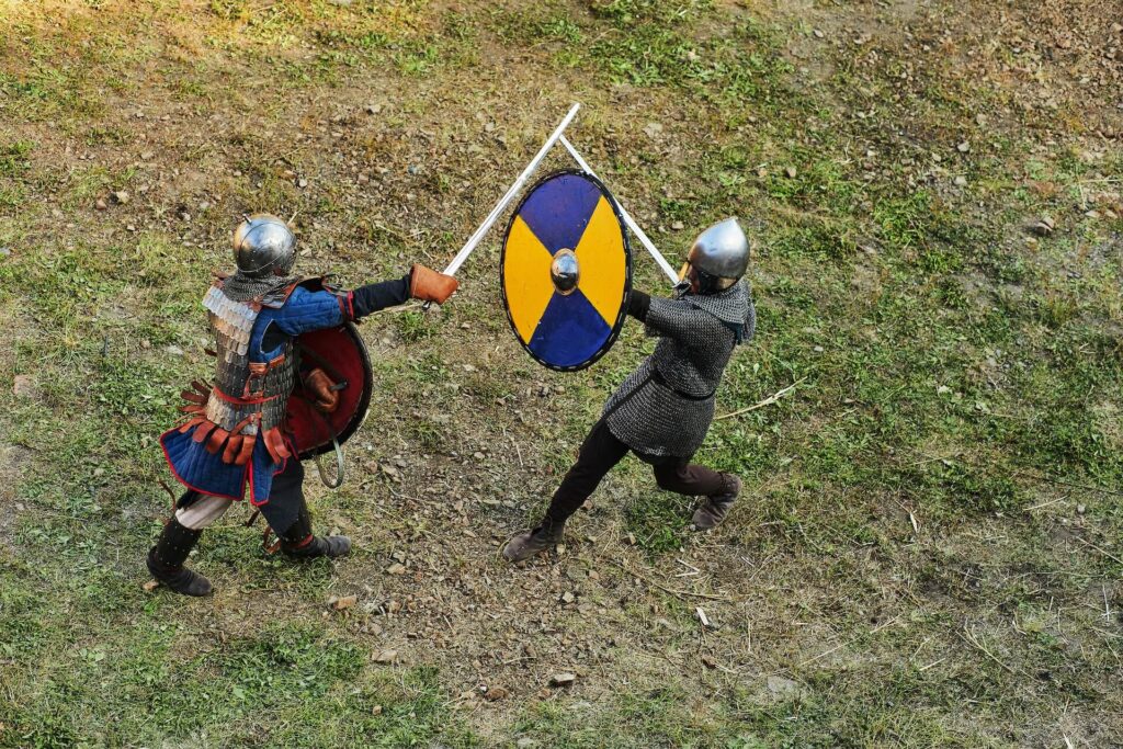 Two men wearing LARP armor while swordfighting