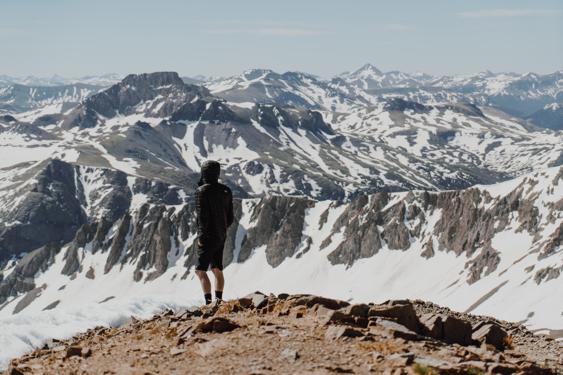 A man in a hiking jacket alone on a mountain