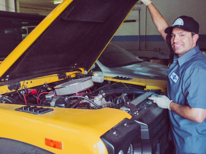 Man standing over the hood of a car