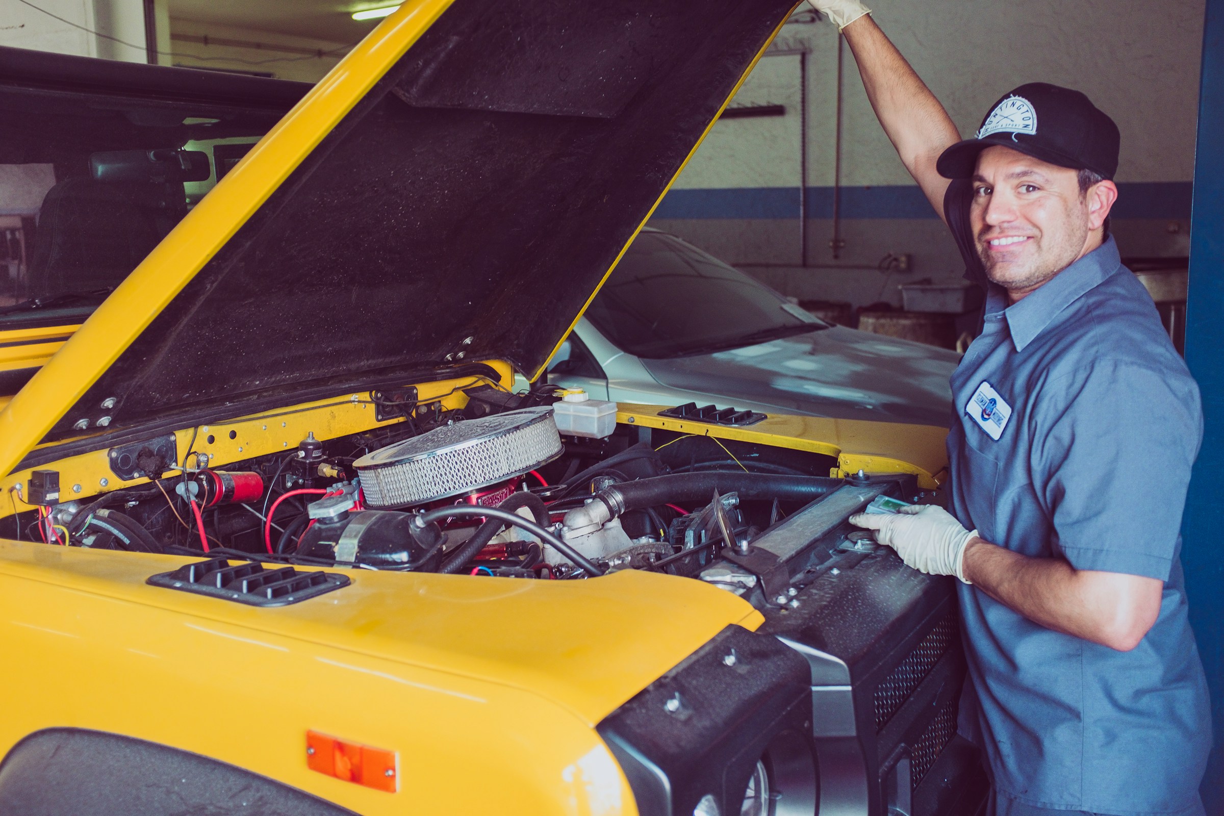 Man standing over the hood of a car