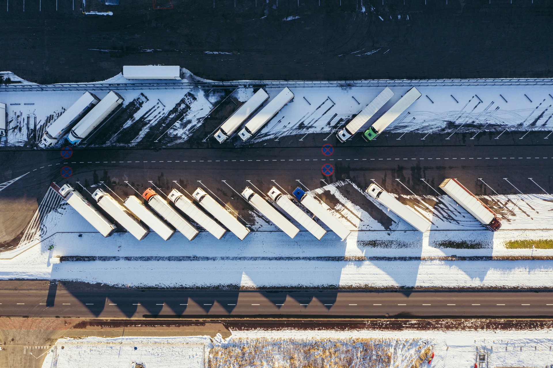 Overhead view of many parked semi trucks