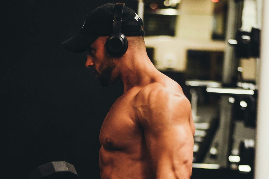 A man lifting weights at the gym while listening to music