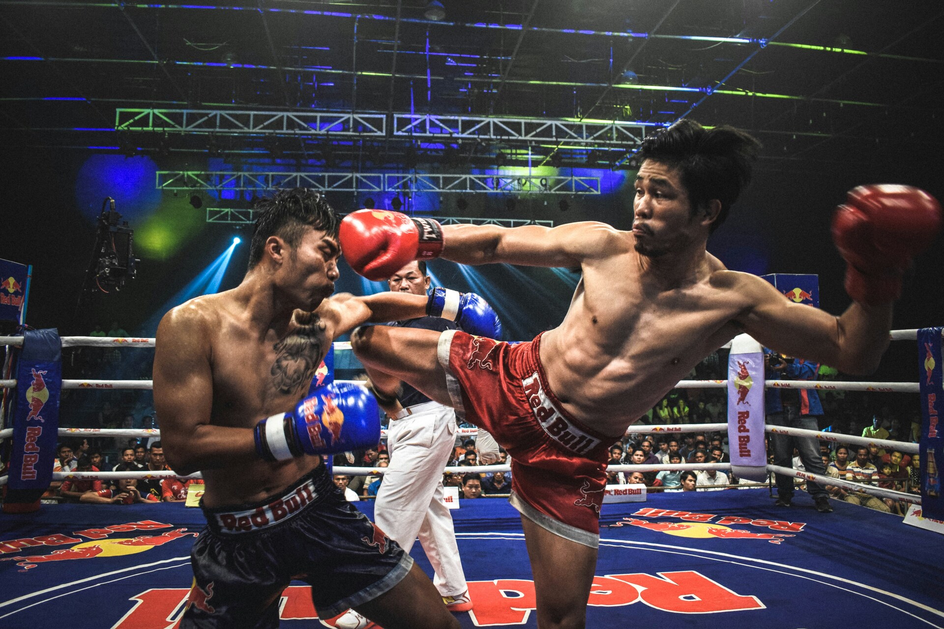 Two kickboxers fighting against each other in a boxing ring