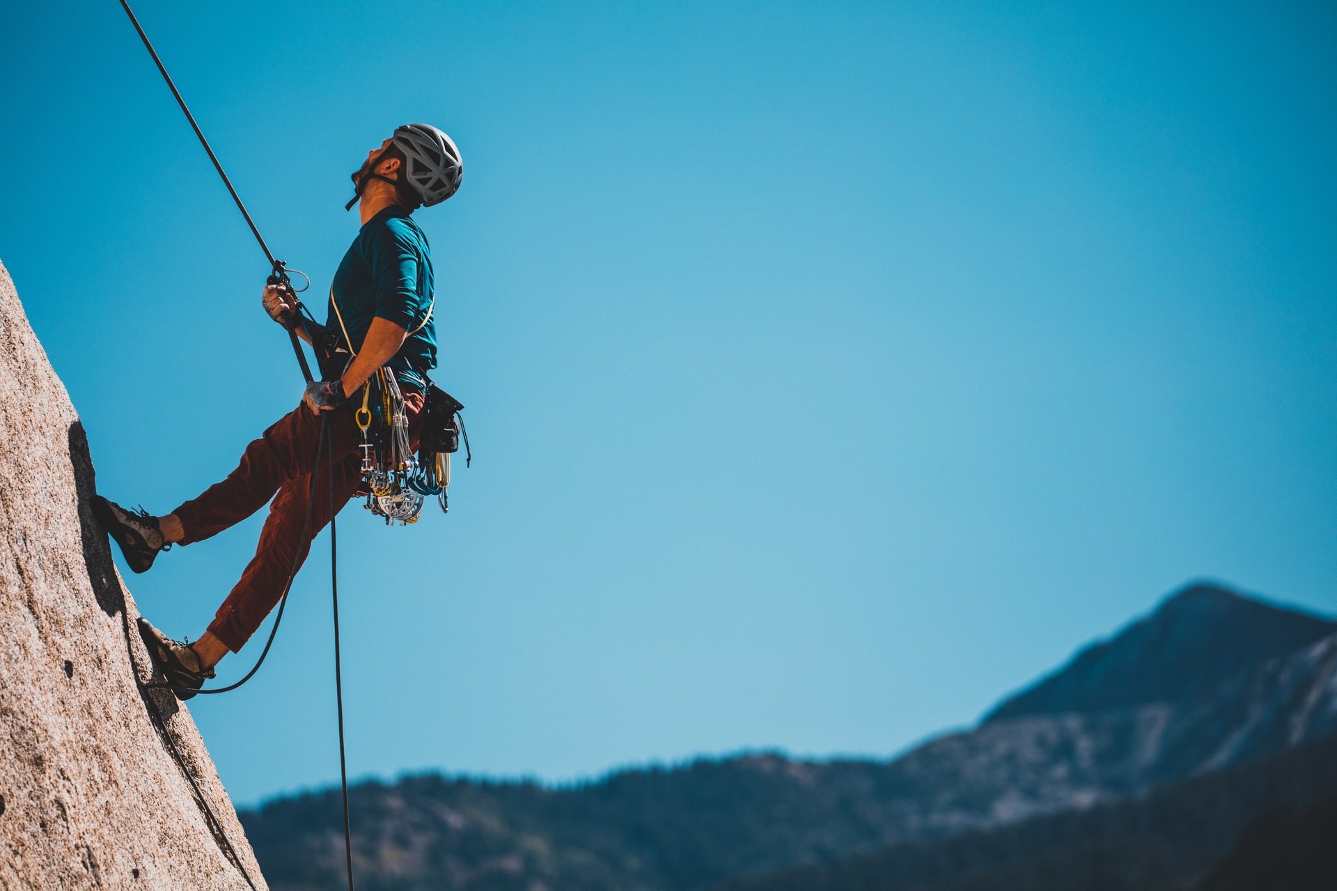 A man climbing up the side of a mountain