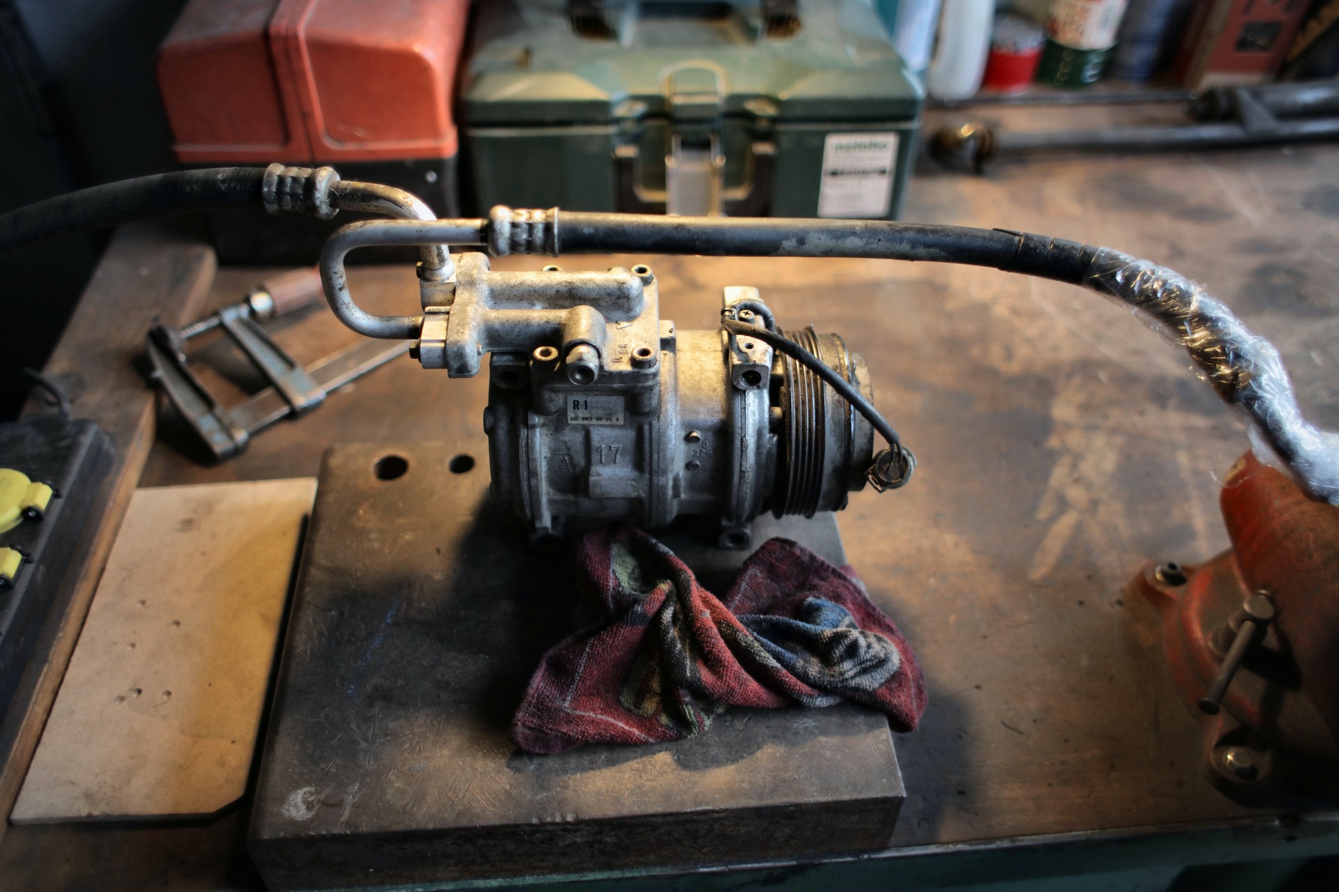 A metal air compressor on a workbench.