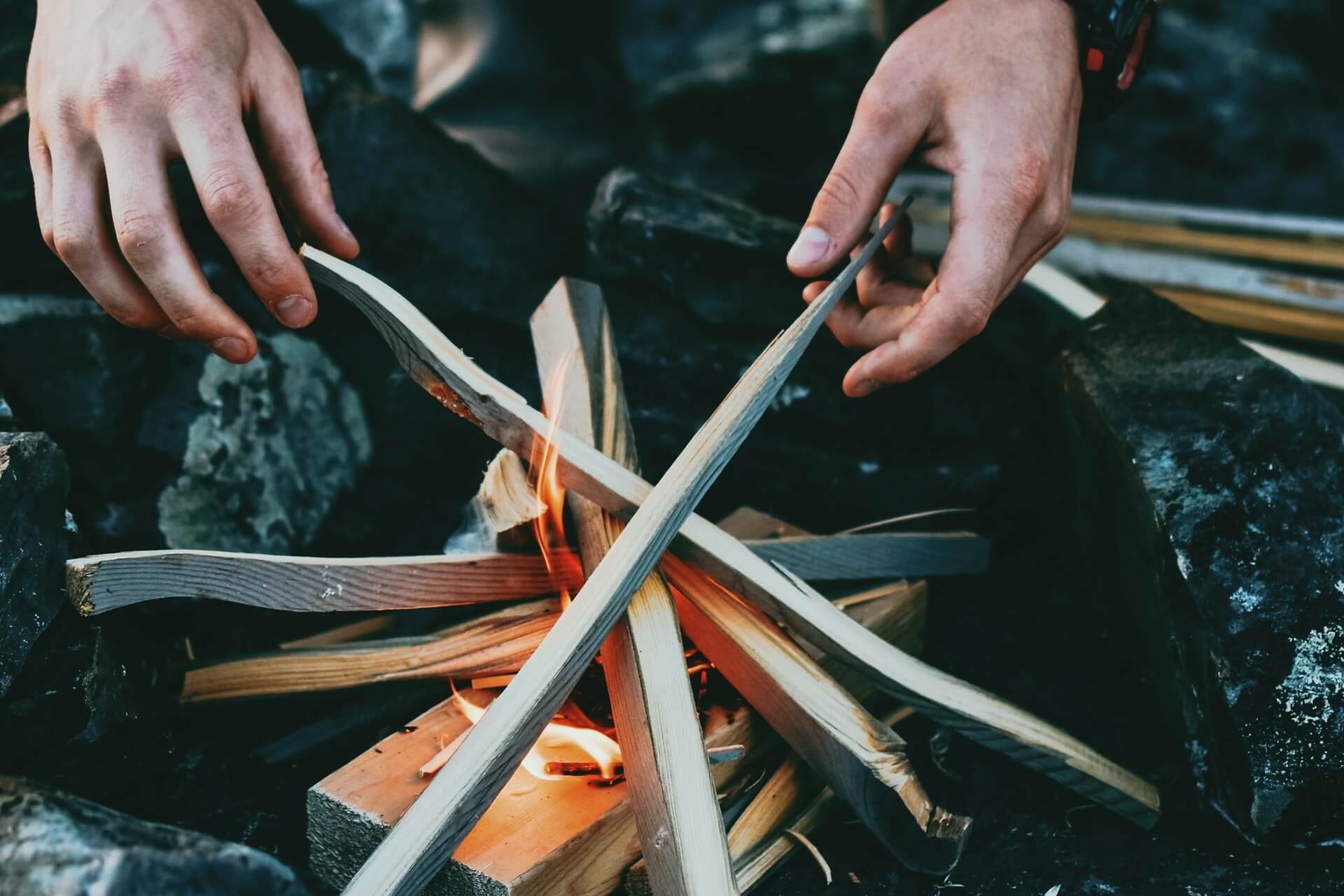 Man prepping by creating a fire.