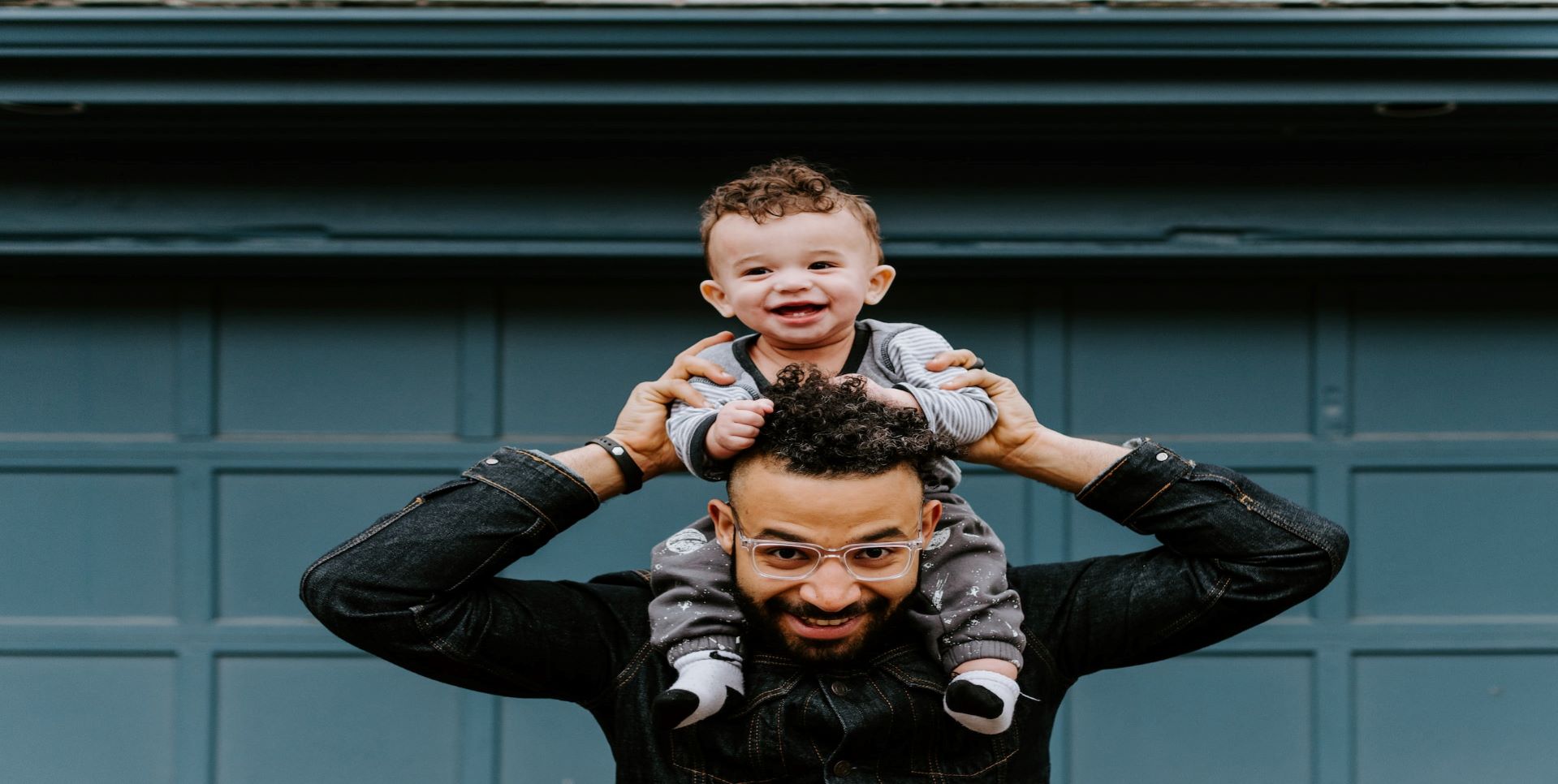 Man holding baby on shoulders.