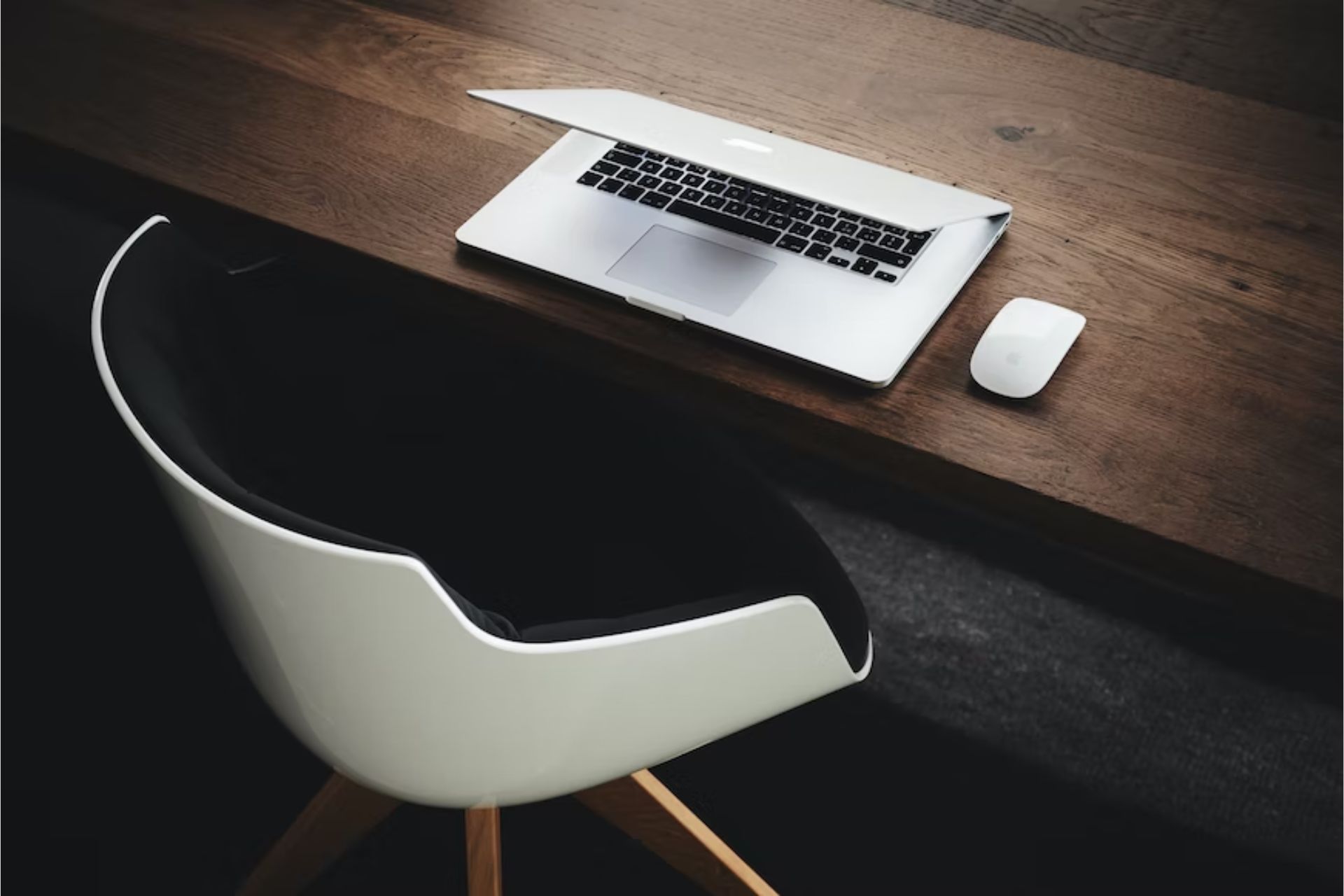 Chair beside table with laptop.